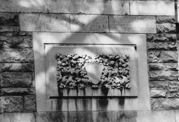 Carved stone shield and flower detail on the exterior of the Chi Psi Lodge Fraternity house at 150 Iota Court.