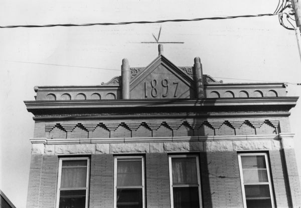 Exterior view of a brick building at 461 West Gilman Street, which has the date it was built, 1897, displayed prominently on the front.