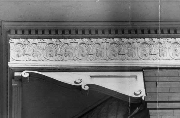 Exterior detail of the Bethel Lutheran Parrish Shop, 315 North Carroll Street featuring a decorative corbel and frieze along the top of the front porch. Also known as the Halle Steensland House.