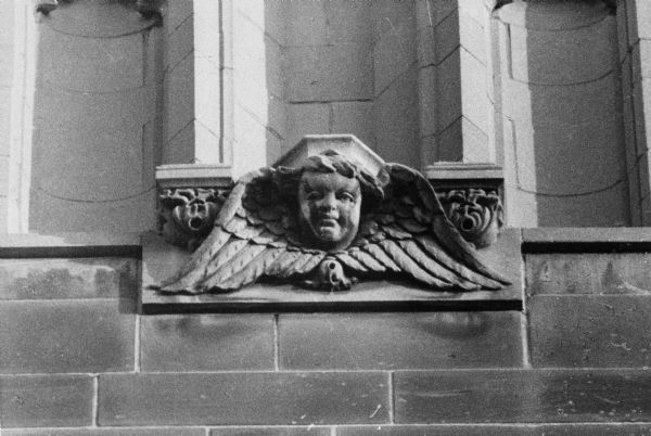 Carved stone angel and wings detail on the exterior of the Lutheran Memorial Church at 1021 University Avenue.