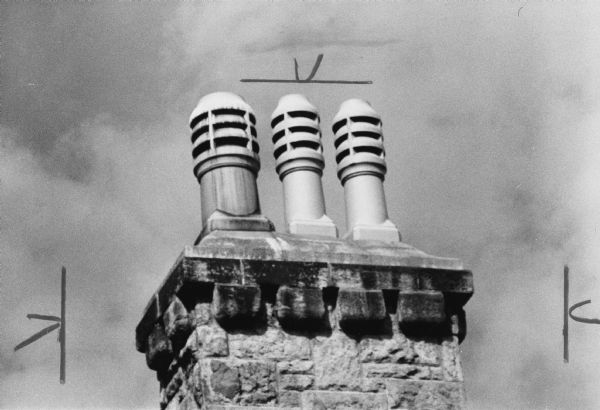 Three chimney pots atop a stone chimney on a house at 415 North Carroll Street.