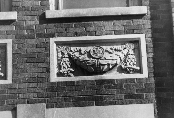 Renaissance style detail known as swag, which is a stone, wood, or plaster design depicting decorative items tied together. This detail is seen on the exterior of the central YMCA at 207 West Washington Avenue.
