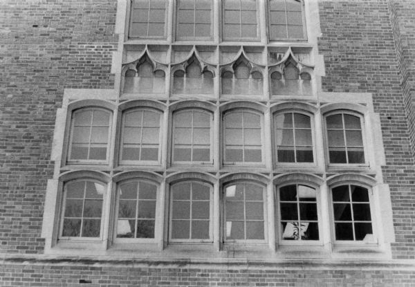 Exterior view of East High School with Gothic architecture reflected in the window tracery.
