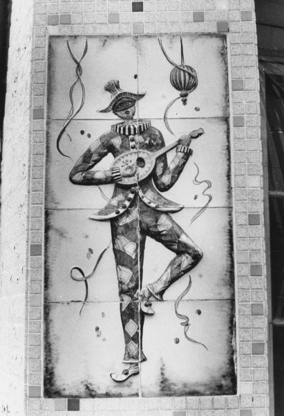 An image of a Harlequin (Arlecchino in Italian), a classical witty comic servant, on a terra cotta panel that decorates Lombardino's Restaurant at 2500 University Avenue.