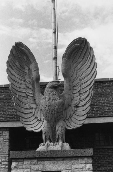 Statue of a stone eagle on a pedestal in front of the Eagles Club at 1236 Jenifer Street.