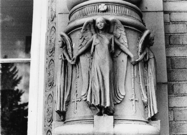 The base of a column at Edgewood High School, 1000 Edgewood Avenue, decorated with angels and crosses that hint at Renaissance style.