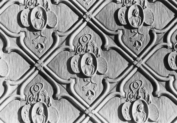 Detail of a terra cotta spandrel at Edgewood High School at 2219 Monroe Street showing religious medallions in relief. Spandrels are roughly tringular areas between the outside curves of arches.