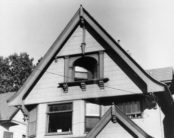 Leaded windows of a house at 541 West Washington Avenue enhanced by decorative features including carved wood brackets and a small arch.