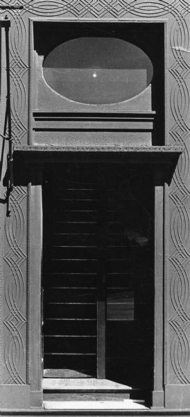 Entrance to a building formerly on the 200 block of East Main Street, featuring careful brickwork and ironcast panels with a curvilinear design. It was torn down to make way for the State Office Building.