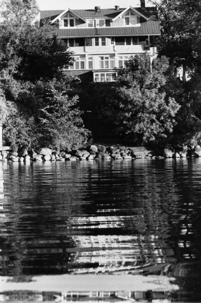 William & Dora Collins House from Lake Mendota, 704 East Gorham Street, which contained offices of the Madison Parks Department and later a Bed & Breakfast Inn. The design of the house is representative of the turn-of-the-century Prairie School style in its horizontal lines and simple geometric shapes. It was built in 1912 and was designed by the architectural firm of Claude and Starck.