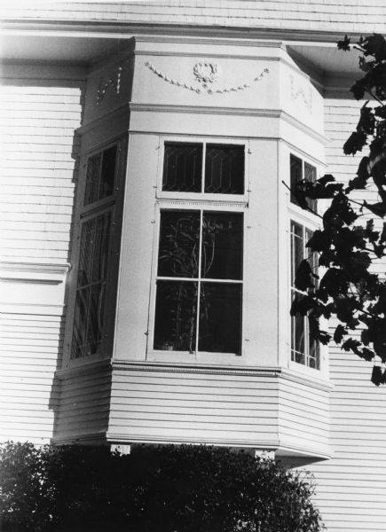 A Tudor style oriel window with a garland decoration on a house at 1717 Kendall Avenue.