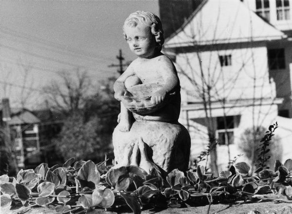 A small sculpture of a girl with little ducks on the front steps of the house at 211 North Prospect Avenue.