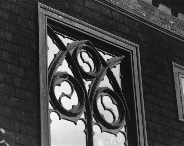 A window frame decorated with ornate carved wood, 115 Ely Place, in a Madison landmark known as the Charles E. Buell House.
