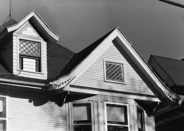 A house at 609 South Few Street on which a row of dentils accents a gable. A dormer window shows handcrafted detail, as do the eaves of the gabled roof.
