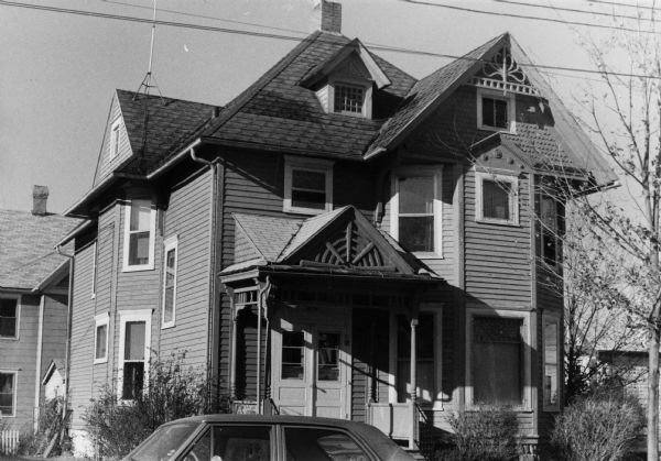 Exterior view of a house at 1254 Rutledge Street which displays several examples of handcrafted detail including crab-like carved woodwork, open gables, and a spiderweb design over the porch.