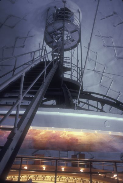 Interior lantern stairway. In the background is the painting, "Resources of Wisconsin," which tops off the inner dome of the Wisconsin State Capitol. Above the painting is the structure of the outer dome.