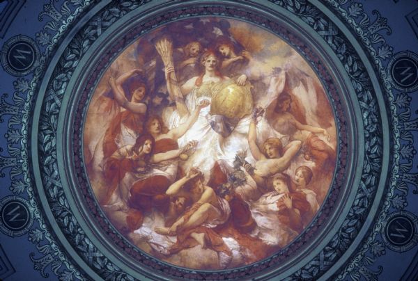 "Resources of Wisconsin," a painting by Edwin Howland Blashfield. The painting is in the inner dome of the Wisconsin State Capitol, and is painted in a segment of a sphere that is 34 feet in diameter and approximately 13 feet high. It sits above a gold entablature and is lit from below. A woman representing Wisconsin is enthroned on clouds and is holding the escutcheon of the Wisconsin State Coat of Arms. Below her are other women wrapped in the United States flag and holding products of the state, including grapes, lead, copper, tobacco, and fruit.