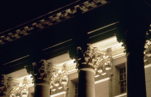 Detail of exterior columns of the Wisconsin State Capitol at night.