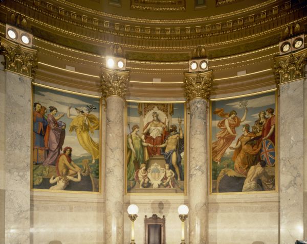The Senate Chamber in the Wisconsin State Capitol. The triptych features three paintings by Kenyon Cox, of "The Marriage of the Atlantic and Pacific," symbolizing the opening of the Panama Canal. In the center, America enthroned,  blesses the union of the two oceans. The left panel Commerce, beckons to Japan and China, behind whom is a figure symbolizing Semitic races. The right panel, Peace, welcomes France with the artist's palette, Germany, with the book of Science, and Great Britain.