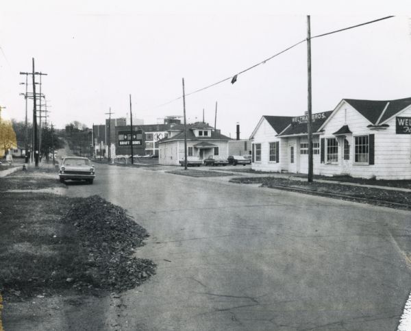 Town Line Road in Wausau, showing the Weltman Brothers furniture store and, in the background, a Kraft Foods building. Some road work appears underway in the foreground.