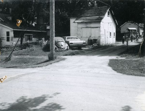 View of an Elroy alley from Cedar Street. The deteriorating garage in the foreground is of an unusual design.