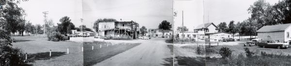 Intersection in Fremont, Wisconsin, showing two service stations. The panorama was created by the Department of Transportation by taping together three prints. However, the image on the right was incorrectly joined. In the scan the image is properly placed, although leaving a blank between two photographs.