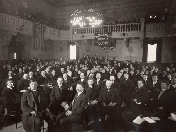 A convention of Russian immigrants at Beethoven Hall in New York City.  The newspaper caption for this photograph describes the Bolshevik communist faction as having used "steam roller" tactics which caused a storm of protests from the representatives of other organizations that were present.