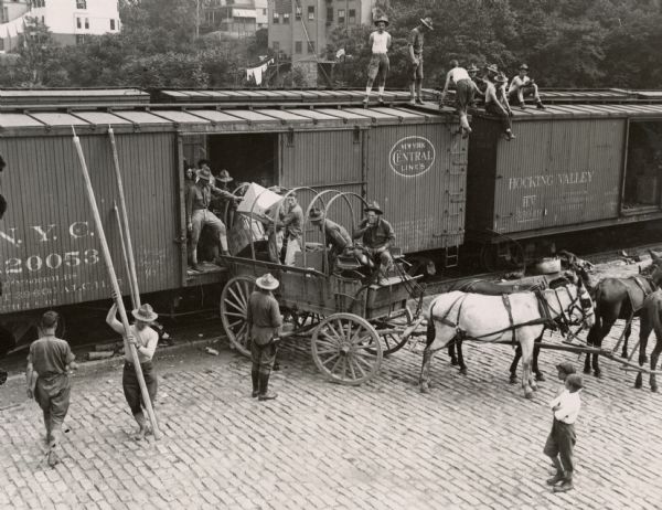 National Guard troops unloading their supplies from New York Central railroad cars into a transport wagon to be taken to camp.