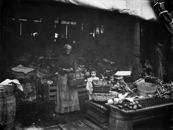 A woman and two young children are shown in a farm market.