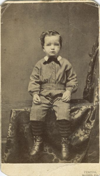 Carte-de-visite portait of Joseph Keyes, the son of Madison political leader Elisha W. Keyes and Caroline Stevens Keyes. Although photographed in a seated position, all of the details of his checkered outfit are visible.
