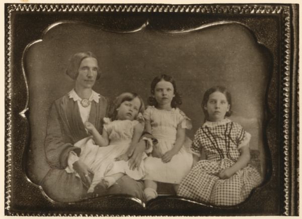 Portrait of the family of Dr. Joseph Hobbins of Madison: Sarah Badger Jackson Hobbins holding her daughter Alice Russell Hobbins (1853-1926), Sarah Ellen Hobbins (1851-1926), and Syndonia Josephine Hobbins (1848-1934), copied from a lost daguerreotype taken in Madison about 1856.