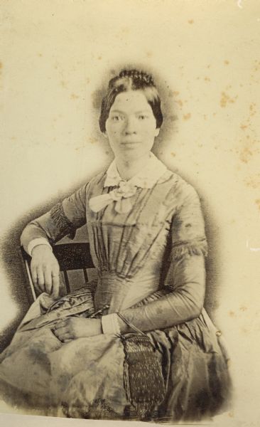 Sarah Goodnow married early Madison settler Darwin Clark in 1848 and died in Madison in 1854.  Her sister Sophia was married to Madison pharmacist Philo Dunning.  This portrait of Mrs. Clark was probably copied from a lost daguerreotype.  Her accessories in this portrait include a small beaded handbag.