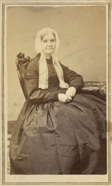 Seated carte-de-visite portrait of Maria A. Morrison, born Maria Amelia Hickox in 1800, the wife of Wisconsin pioneer James Morrison. With her husband, Mrs. Morrison settled in western Wisconsin in 1829, moving to Madison in 1839. James Morrison took his own life in 1860, and Mrs. Morrison is unquestionably dressed in mourning in this photograph. She died in California in 1866.