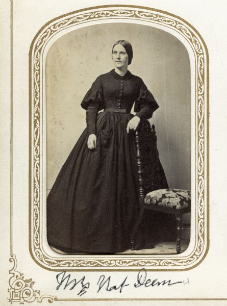Full-length carte-de-visite portrait of Harriet Morrison Dean, the wife of Nathaniel Dean of Madison. Mrs. Dean was born in Dodgeville in 1829, moved to Madison in 1839, and married in 1847. It is likely this photograph was taken about 1860, the year in which her father, Wisconsin pioneer James Morrison, committed suicide, for she is in mourning dress. Her only child died in 1851 and her husband died in 1880. She moved to California and died there in 1900. The image is copied from a Lucius Fairchild family carte-de-visite album to whom she was also related by marriage.