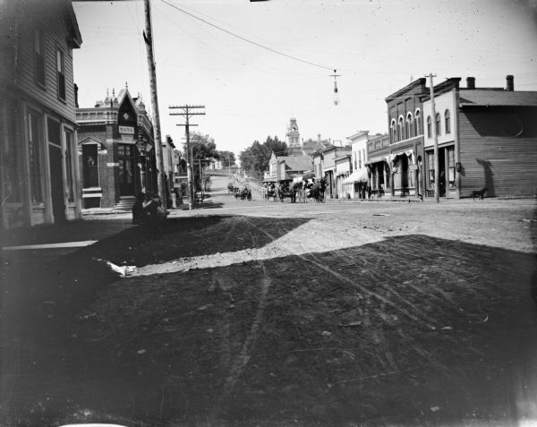Looking west on Main Street toward the intersection of the Main Street and First Street with a long line of carriages coming down Main Street. Jackson County Bank is on the left.