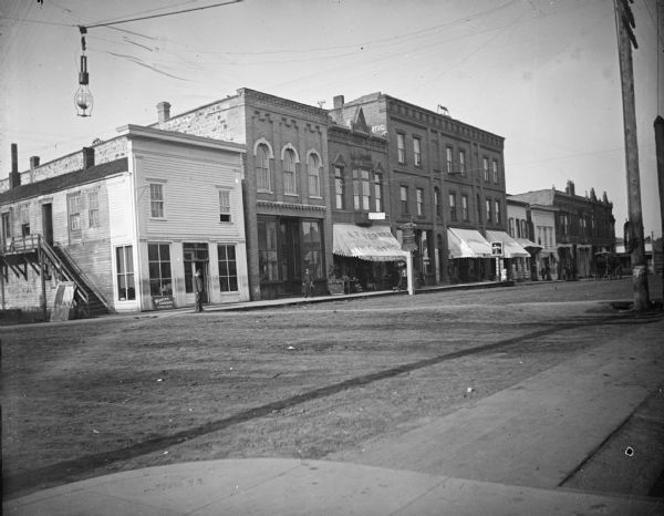 Corner of Main and First Street. The first two buildings on the southwest corner are Abraham Meinhold's dry goods and LeClair's hardware store. Next is A.F. Werner's clothing store, then the First National Bank, and the 5th is the Cole Drug Store.