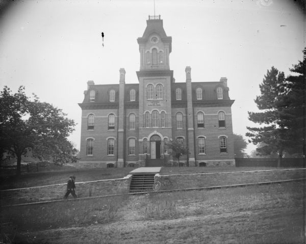 Front view of Union High School with several people and a bicycle in the foreground.