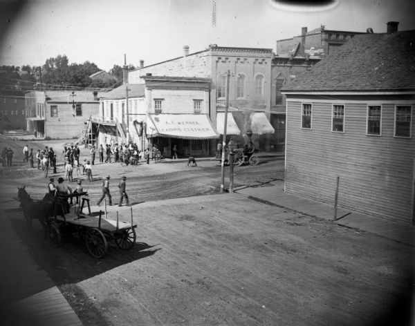 Elevated view of a steam tractor on Main Street with a crowd of men. A.F. Werner is located on the northeast corner of the intersection.