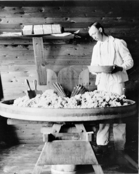 Man packing butter in a creamery.