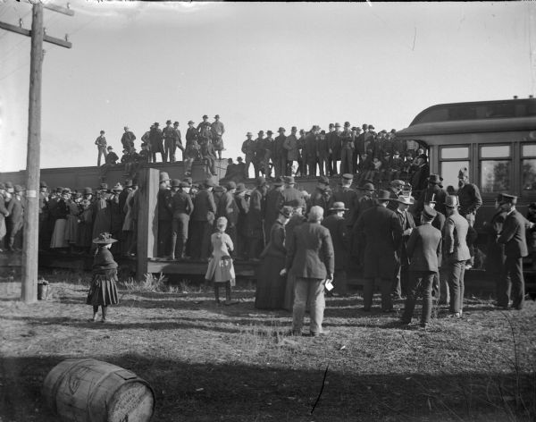 Crowd at station listening to a whistle-stop speaker at a railroad station, possibly Taft.