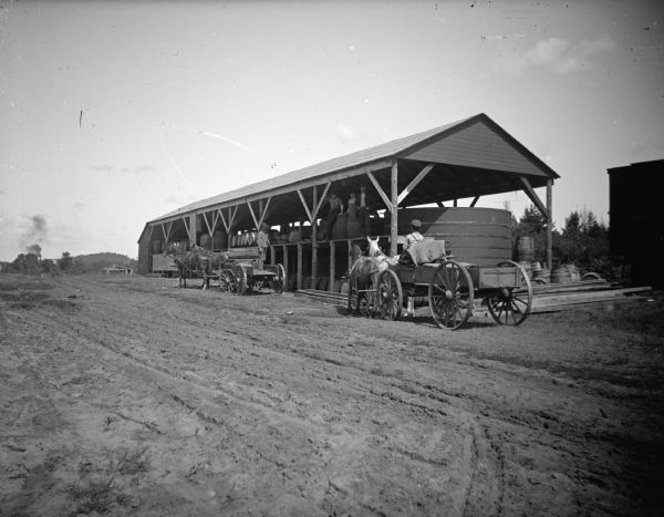 Men loading barrels on horse-drawn wagons, probably the Onalaska Pickling and Canning Company on Winnebago Avenue.