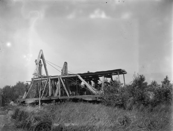 Walking dredge in operation, to rid the county of marshes, probably on the east side of Jackson County. Men working in lower left.
