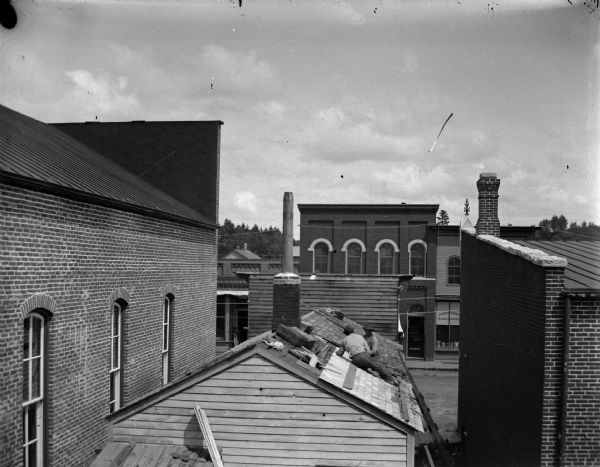 Men roofing a building in town.