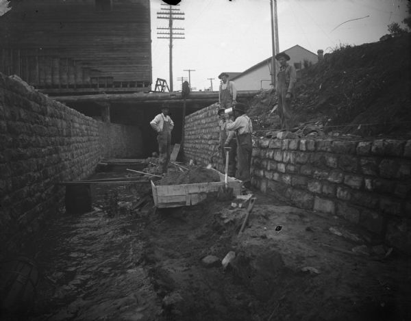 Men working on the passage of Town Creek under First Street, one-half block north of Main Street.