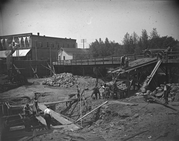 Men laying the foundation for the post-flood business district dam.