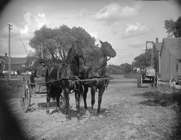 J.A. "Abe" Bailey, the horse dealer, at the corner of Second and Fillmore streets, looking east, with a wagon and team of two horses.