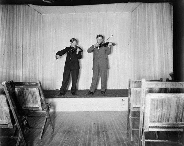 Pair of violinists practicing on the stage of the Opera House.