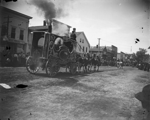 Rear view of a steam calliope in a circus parade in town. A calliope is a musical instrument that produces sound by sending steam through whistles, originally locomotive whistles.