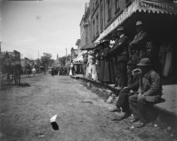 Spectators watching a parade in front of Jones and Marsh Clothing on Main Street.