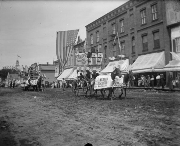 Group of people in A.F. Werner Drugstore wagon riding in parade.	